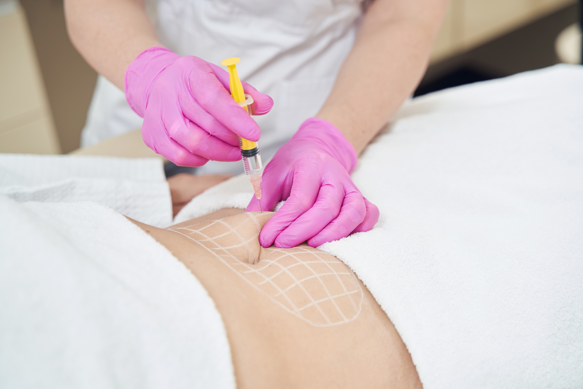 Unrecognized dermatologist is making injection for contouring body in clinic